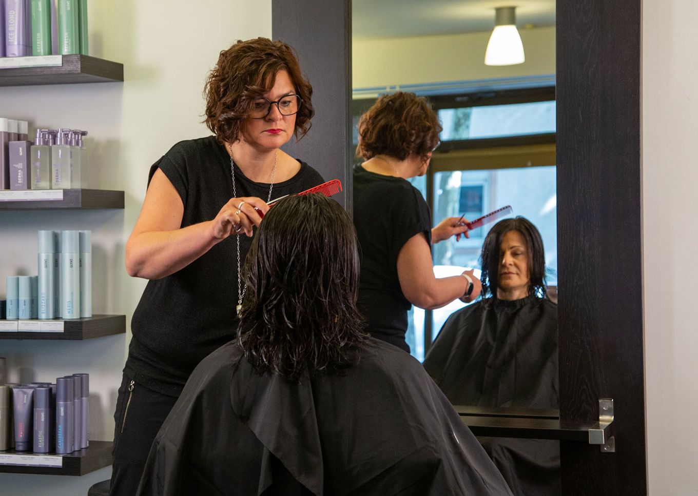Inhaberberin und Master-Stylistin Nicole Jöst-Braun frisiert die langen Haare einer Kundin