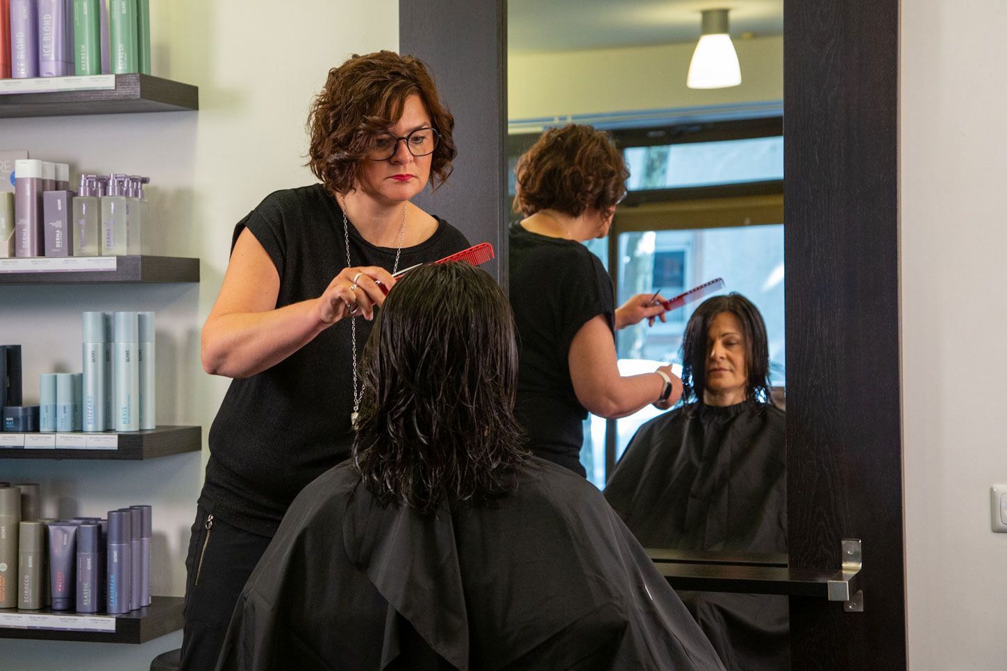 Inhaberberin und Master-Stylistin Nicole Jöst-Braun frisiert die langen Haare einer Kundin
